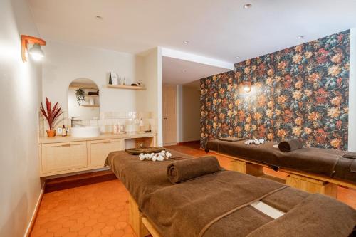 a living room with two beds and a kitchen at Villa Camille Hotel & Spa in Banyuls-sur-Mer