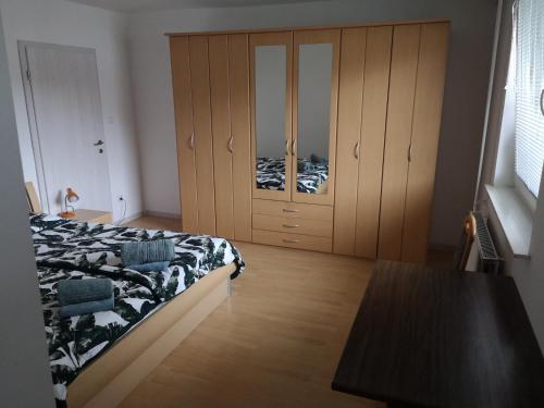 a bedroom with a bed and wooden cabinets at Sobe Zeleni raj in Podnart