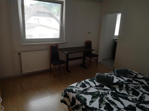 a bedroom with a bed and a table and a window at Sobe Zeleni raj in Podnart