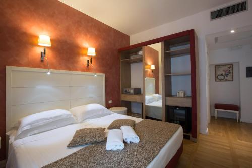 a bedroom with a large bed with towels on it at Floris Hotel in Rome