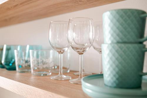 a row of wine glasses sitting on a shelf at Blue Beach Apartman in Zamárdi