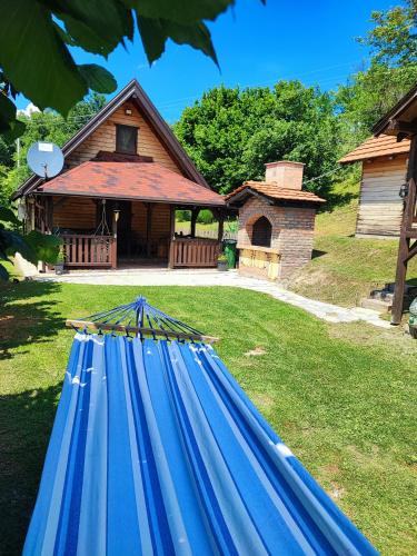 a blue hammock in front of a house at Brvnara na bregu in Bajina Bašta