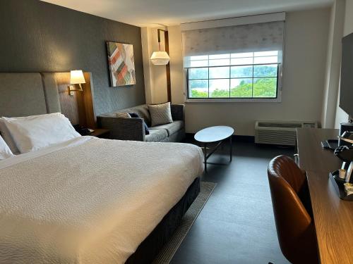 Habitación de hotel con cama y sala de estar. en Holiday Inn Niagara Falls-Scenic Downtown, an IHG Hotel, en Niagara Falls