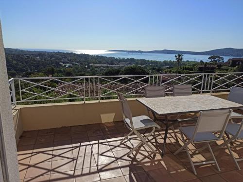 eine Terrasse mit Tisch und Stühlen auf einem Balkon in der Unterkunft Les Restanques, Bastides 3105, vue Golfe Saint Tropez in Grimaud
