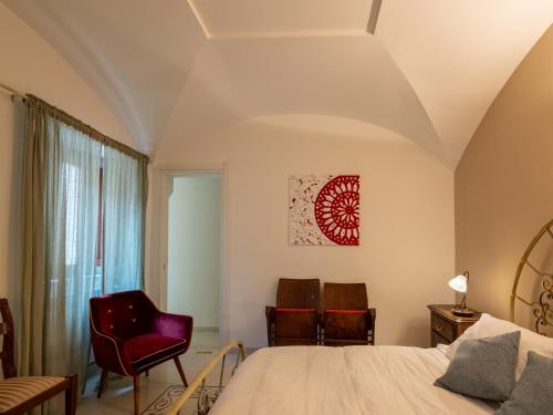 a bedroom with a bed and two chairs at Dimora del Padre Provile 1244 - Centro storico in LʼAquila