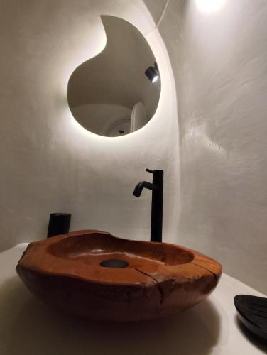 a bathroom with a wooden sink with a mirror at The Magic Luxury Cave Suites in Vóthon