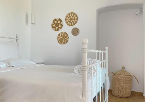 a bedroom with a white bed and some plates on the wall at Haroto Suites in Tripiti