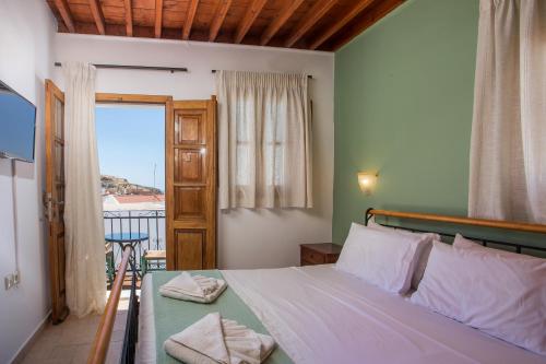 a bedroom with a bed and a door with a balcony at Villa Sakura in Lindos