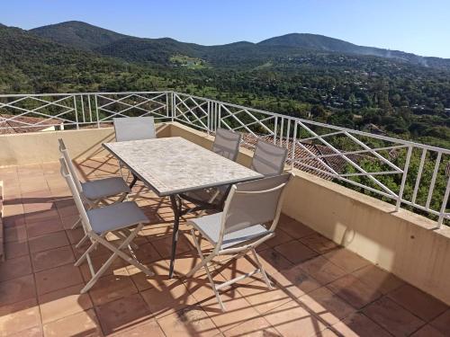 ein Tisch und Stühle auf einem Balkon mit Aussicht in der Unterkunft Les Restanques, Bastides 3105, vue Golfe Saint Tropez in Grimaud