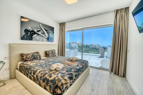 sypialnia z łóżkiem i dużym oknem w obiekcie 2288 new modern penthouse with privat pool w mieście Estepona