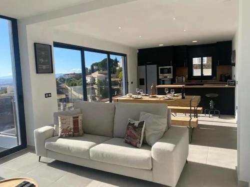 un soggiorno con un divano bianco e una cucina di Modern House with City View in El Mas Fumats a La Selva de Mar