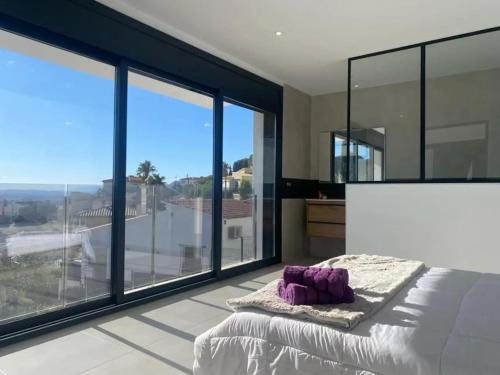 una camera con letto e ampie vetrate di Modern House with City View in El Mas Fumats a La Selva de Mar