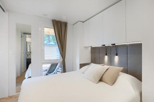 a bedroom with a white bed and a window at Holiday Mobile Homes Park Riviera in Novigrad Istria