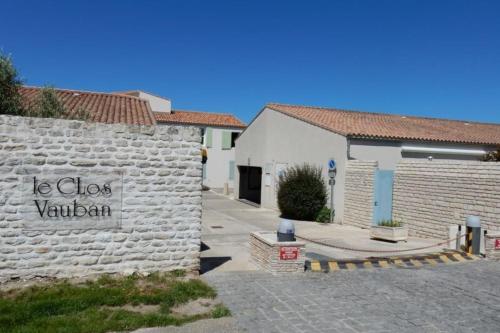 un mur de pierre avec un panneau indiquant qu'il a fermé Vaughan dans l'établissement Appartment with courtyard and garden 300 m from the port and from the beach, à Saint-Martin-de-Ré