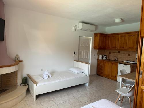 a room with a white bed in a kitchen at NikLuDin suites & studios in Laganas