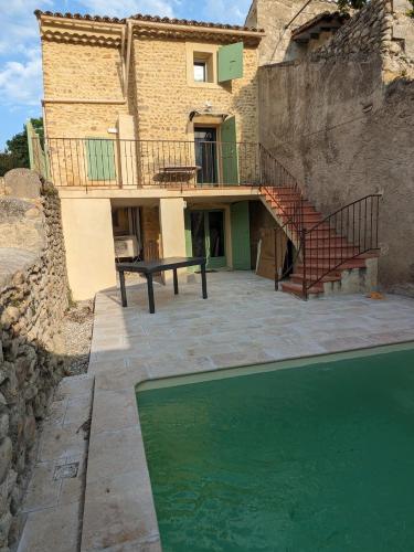 une maison avec piscine devant un immeuble dans l'établissement Maison de village en Provence, à Saint-Roman-de-Malegarde