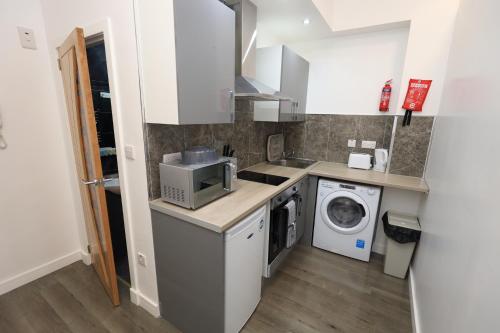 a kitchen with a washing machine and a washer at VR Apartments in Glasgow