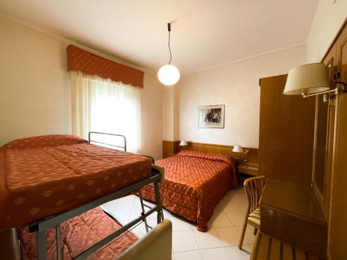 Postel nebo postele na pokoji v ubytování Hotel Garni del Lago