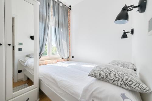 a small bedroom with a bed and a window at DR Apartments - Parkowa in Sopot