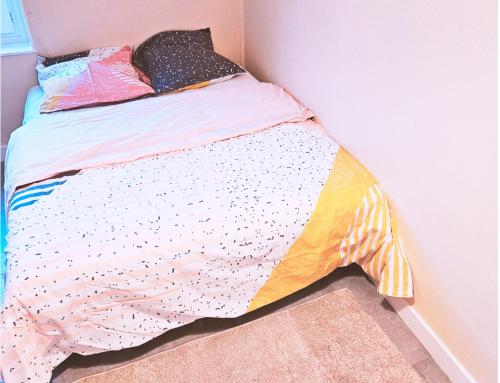 une chambre avec un lit avec une couette colorée dans l'établissement Le Mahanaim House, à Nevers