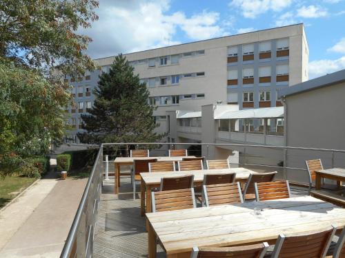 a cafeteria with tables and chairs in front of a building at Ethic étapes Val de Loire in Blois