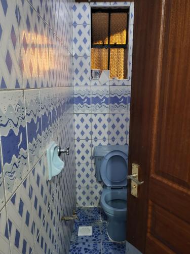 a bathroom with a blue toilet and a window at G&G Homes Nakuru CBD in Nakuru