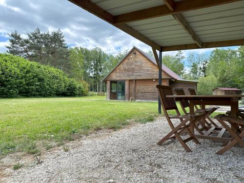 - une table de pique-nique en bois et un banc sous un pavillon dans l'établissement Le refuge de Chambord, à Thoury