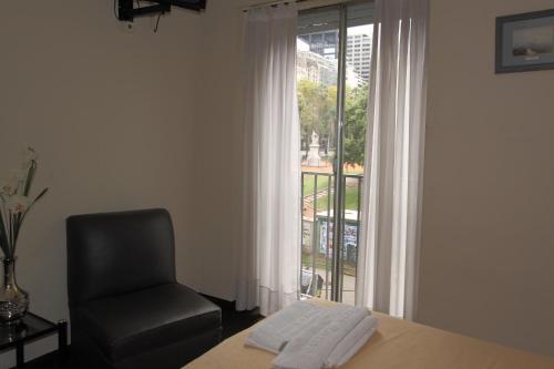 a room with a chair and a table and a window at Hotel Plaza Roma in Buenos Aires