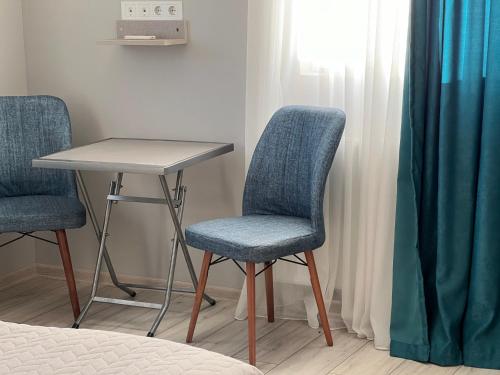 two chairs and a table in a room with a bed at Семейная гостиница Гантиади in Batumi