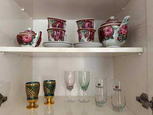 a shelf with wine glasses and vases on it at Семейная гостиница Гантиади in Batumi
