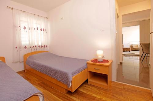 a bedroom with a bed and a lamp on a table at Apartment Vanja in Bol