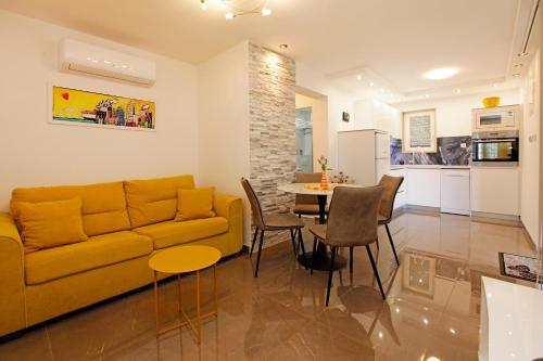 a living room with a yellow couch and a table at Apartment Vanja in Bol