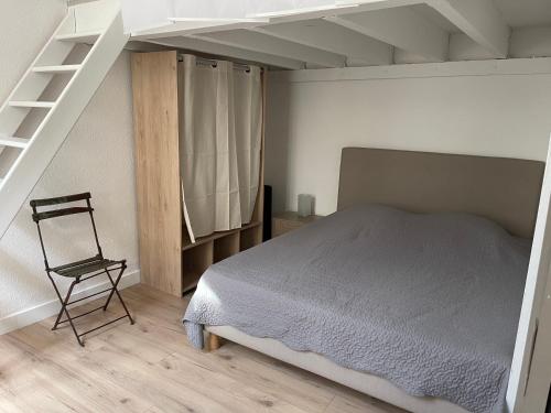 - une chambre avec un lit, une échelle et une chaise dans l'établissement Coeur de ville AVIGNON, à Avignon