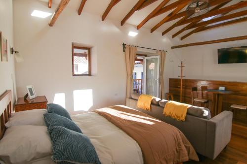 una camera da letto con un letto e un divano in una stanza di SONQO, apartamento con lindas vistas en Cuesta san Blas 561 a Cuzco