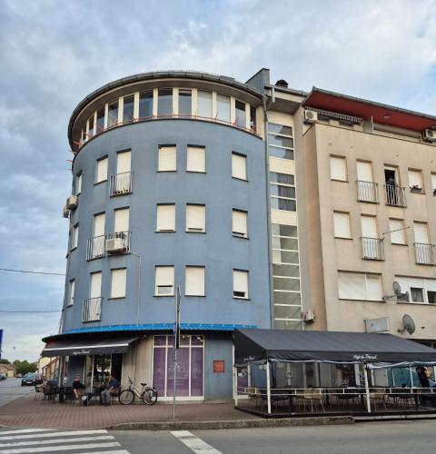 a tall blue building with a table in front of it at Studio apartman Zubak in Ðakovo