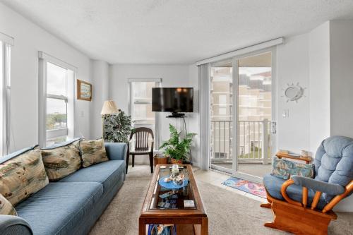 a living room with a blue couch and a table at Dolphins Den in North Topsail Beach
