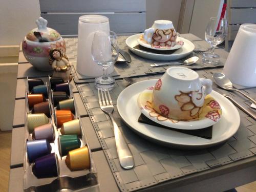 a table with plates and cups and utensils on at B&B Il Piccolo Principe room and breakfast in Bieno