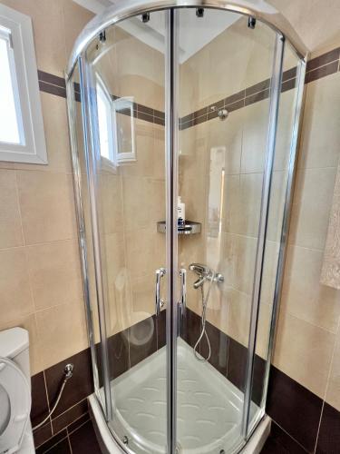 a glass shower in a bathroom with a toilet at Nikiti Sunny House in Skála Nikíta
