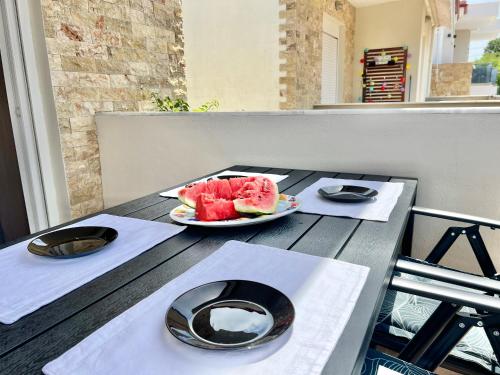 a table with two plates of watermelon on it at Nikiti Sunny House in Skála Nikíta