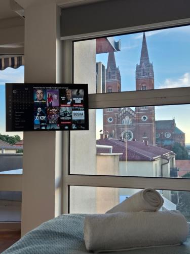 a bedroom with a window with a view of a building at Studio apartman Zubak in Ðakovo