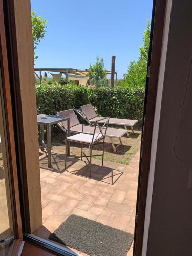 an open door to a patio with chairs and tables at Resort Fonte Vulci in Canino