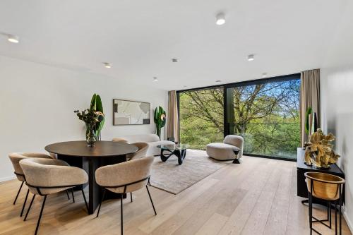a living room with a table and chairs at Spacious 6th-Floor Gem: Modernity Meets Comfort in Luxembourg
