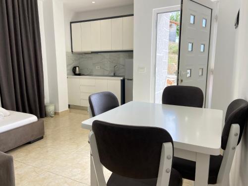 a dining room with a white table and chairs at Villa Bodini Himare in Himare