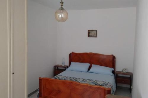 a bedroom with a wooden bed with two pillows at Cà du Brenta Casa nel cuore della Liguria in Chiusavecchia