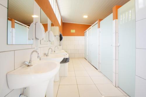 La salle de bains est pourvue de 3 lavabos et de 2 miroirs. dans l'établissement VELINN Camping Ilhabela, à Ilhabela