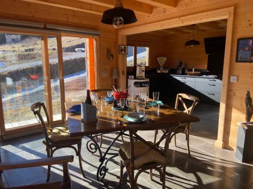 a dining room with a wooden table and chairs at CHALET LUANE près de VALBERG in Beuil