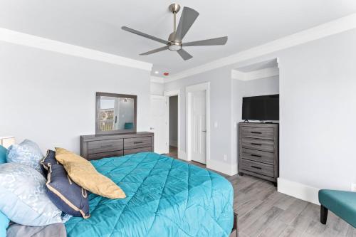 a bedroom with a blue bed and a flat screen tv at Dune Our Thing North Topsail Beach in North Topsail Beach