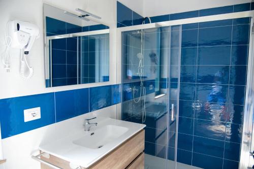 bagno piastrellato blu con lavandino e doccia di Al Ficheto Bed and Breakfast ad Agropoli