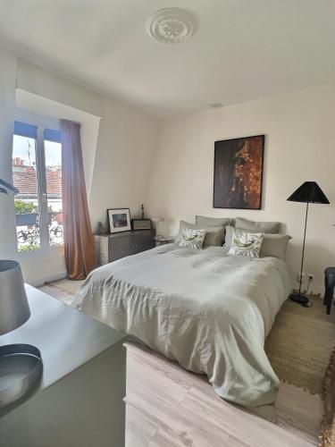 une chambre blanche avec un grand lit et une fenêtre dans l'établissement APPARTEMENT PARIS 11 Quartier Saint Maur, Oberkampf, à Paris