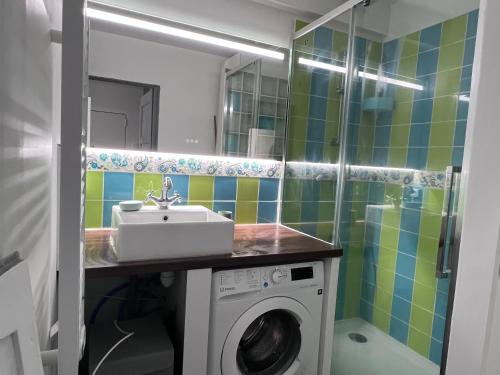 une salle de bain avec une machine à laver et un lavabo dans l'établissement Appartement Cosy Capelette, à Marseille
